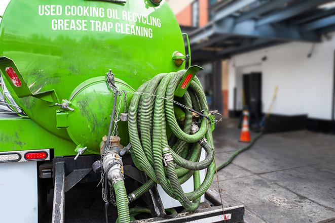 a technician pumping a grease trap in a commercial building in Osawatomie KS